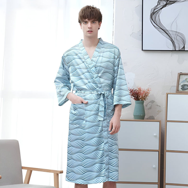 Homme portant un kimono bleu à motifs ondulés. Kimono idéal pour la détente à la maison. Vente de kimonos en ligne.