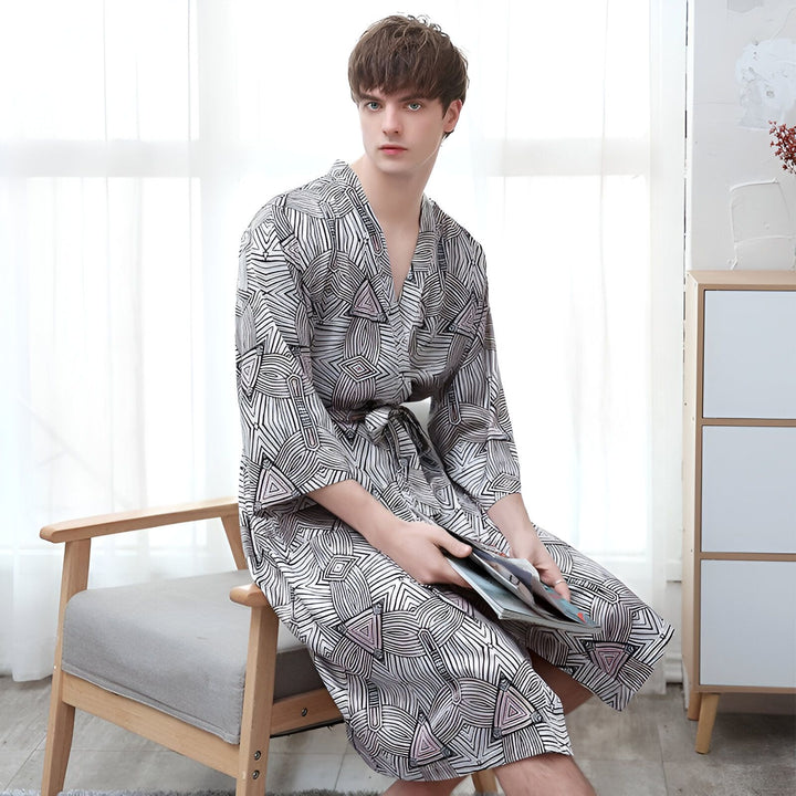 Homme portant un kimono imprimé, assis sur une chaise. Vente de kimonos pour hommes et femmes.