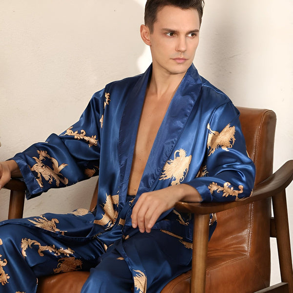 Homme portant un kimono bleu satiné avec des motifs dorés, assis dans un fauteuil. Kimonos pour hommes disponibles à l'achat.