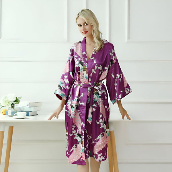 Femme portant un kimono violet à motifs floraux et de paon. Kimono de luxe, robe de chambre élégante. Vêtements de détente, collection kimono.