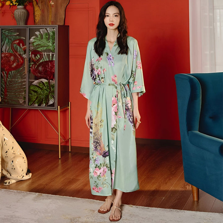 Femme portant un kimono vert clair avec des motifs floraux et de paon. Vêtements d'intérieur élégants. Disponible dans notre boutique en ligne.