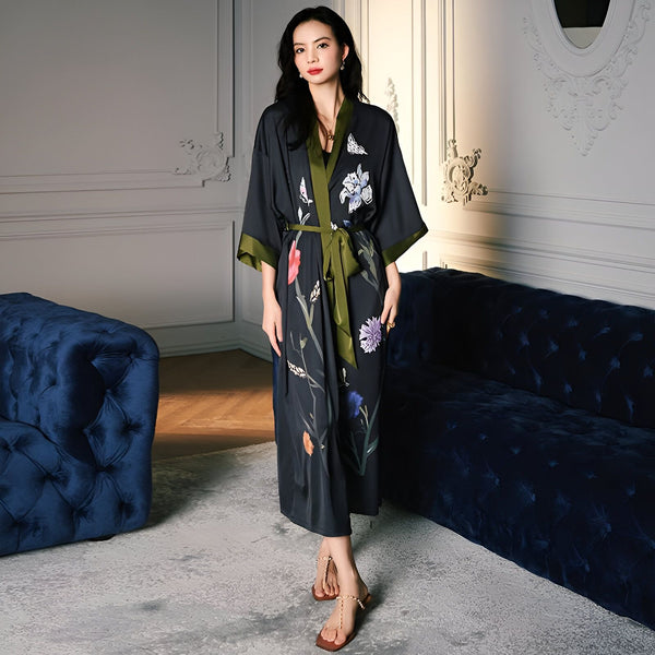 Femme portant un kimono long noir à motifs floraux, ceinture verte. Vente de kimonos en ligne.