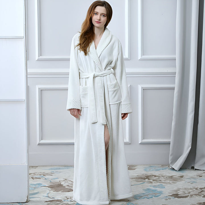 Femme portant un long kimono blanc en tissu doux avec une ceinture. Idéal pour la détente à la maison. Notre collection de kimonos confortables et élégants.