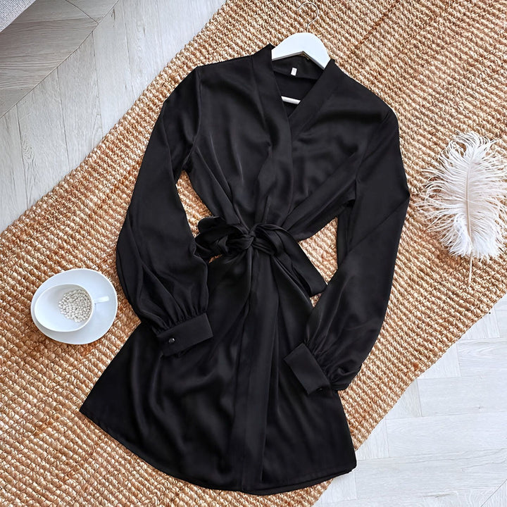 Kimono noir élégant sur un tapis en paille. Vêtement de détente avec manches longues et ceinture. Disponible dans notre boutique en ligne.