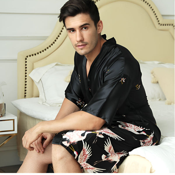 Homme portant un kimono noir en soie avec des motifs de grues et de fleurs. Kimonos élégants pour hommes, vêtements d'intérieur de luxe.