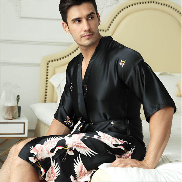 Homme portant un kimono noir en soie, orné de motifs de grues et de fleurs. Vente de kimonos pour hommes.