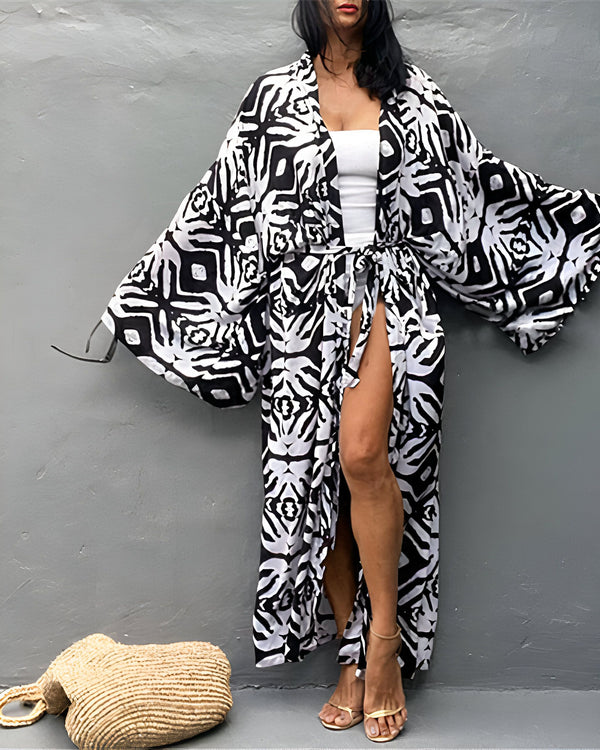 Femme portant un kimono long à motifs noirs et blancs, avec une ceinture nouée. Style décontracté et élégant. Kimonos de notre collection.