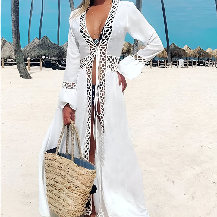 Femme portant un kimono blanc en dentelle à la plage. Kimono long parfait pour les vacances, disponible à l'achat.