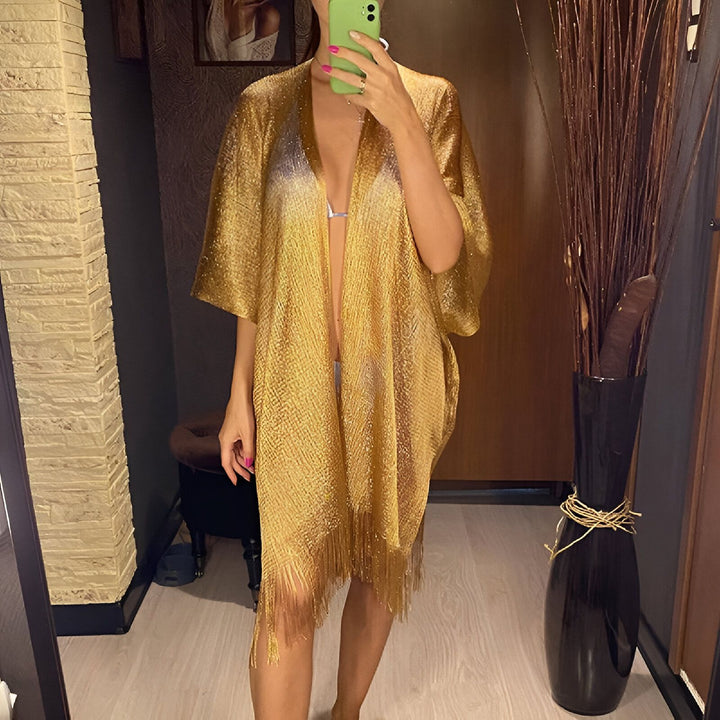 Femme en kimono doré à franges, prenant un selfie. Vêtements kimono élégants et uniques à découvrir dans notre boutique.