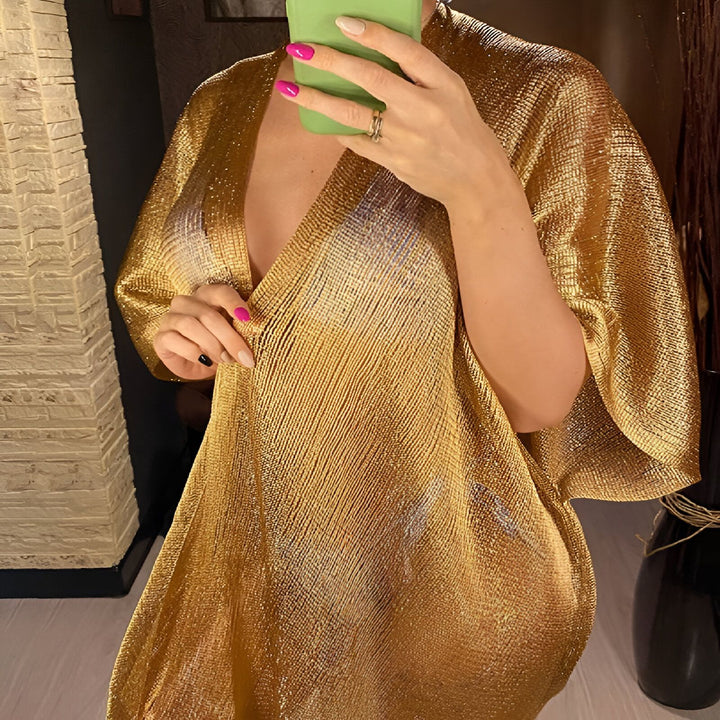 Femme portant un kimono doré étincelant. Vêtement d'intérieur élégant et confortable. Collection de kimonos de notre boutique en ligne.