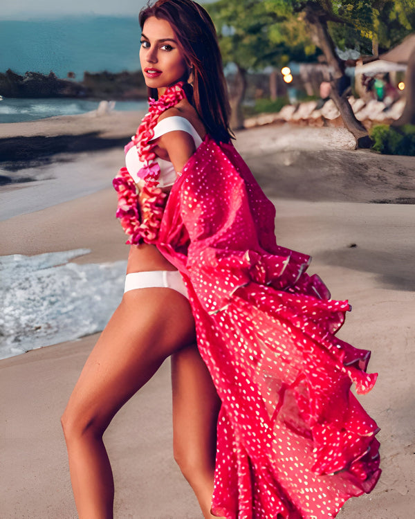 Femme portant un kimono rose à pois sur la plage. Kimonos disponibles à l'achat.