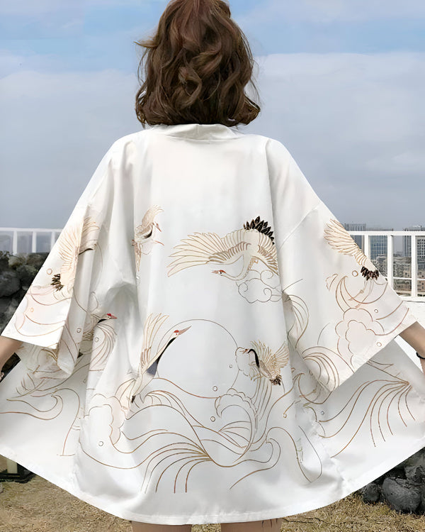 Dos d'une femme portant un kimono blanc avec des motifs de grues dorées. Kimono traditionnel japonais. Vêtement de style asiatique à manches larges.