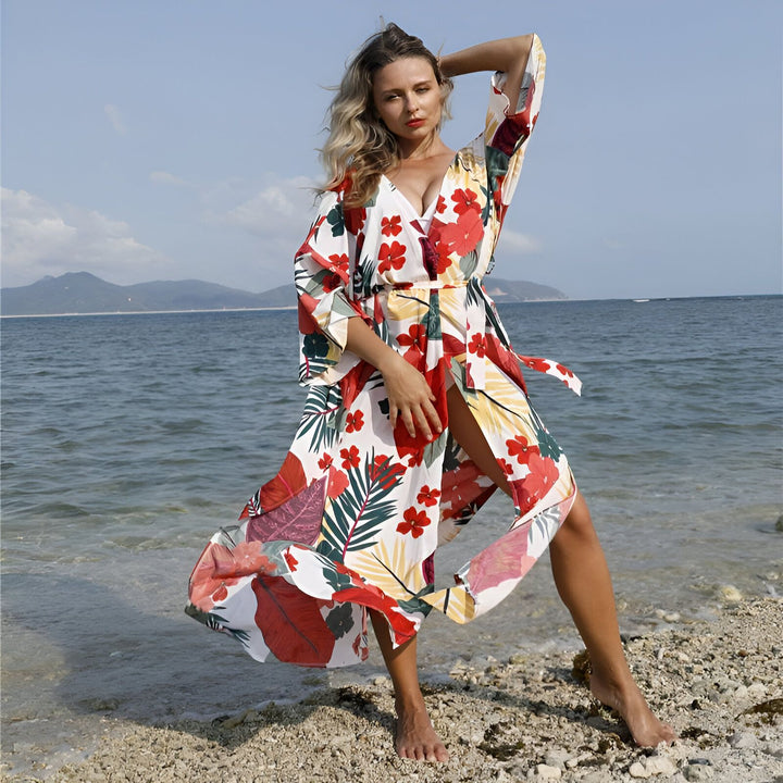 Femme portant un kimono fleuri à la plage. Vêtement d'été léger et élégant, idéal comme couverture de plage ou robe décontractée. Découvrez notre collection de kimonos uniques.