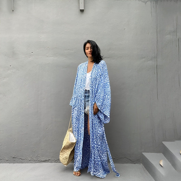 Femme portant un kimono long bleu à motifs, style décontracté et élégant. Découvrez notre collection de kimonos uniques.