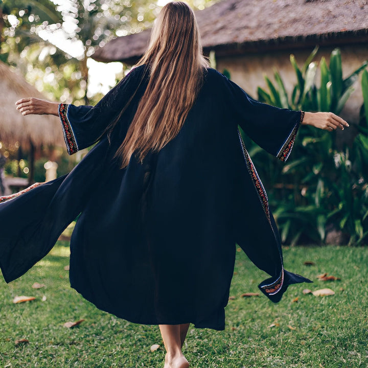 Femme vue de dos portant un kimono noir brodé. Collection de kimonos pour femmes. Style bohème chic.
