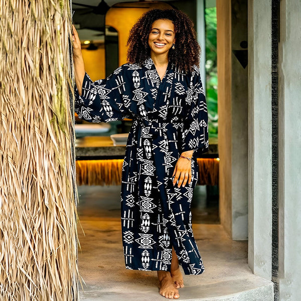 Femme souriante portant un kimono noir et blanc à motifs. Vêtements de détente élégants de notre collection. Kimonos pour femmes, confort et style garantis.