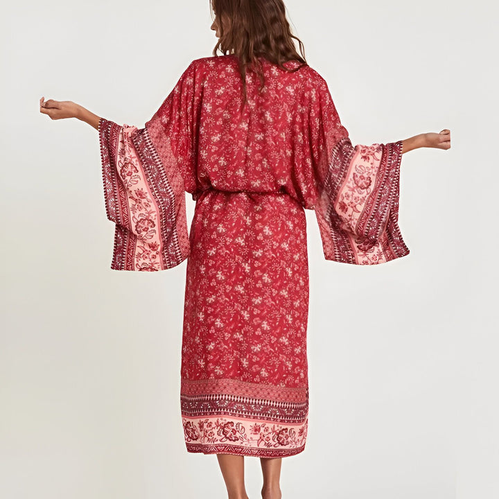 Femme vue de dos, portant un kimono rouge à motifs floraux, manches amples et ceinturé. Vêtements style kimono.