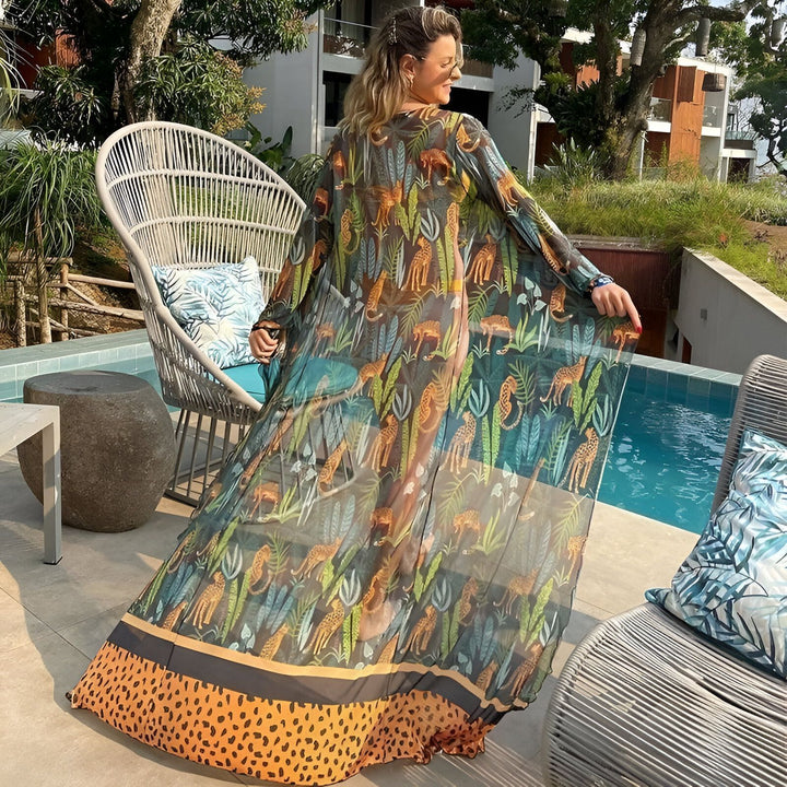 Femme portant un kimono long imprimé léopard, style et élégance au bord de la piscine. Découvrez notre collection de kimonos uniques.