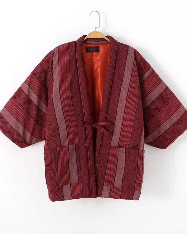 Kimono japonais rayé rouge et bordeaux suspendu. Vêtement traditionnel avec poches et ceinture à nouer. Doublure orange. Boutique de kimonos authentiques.