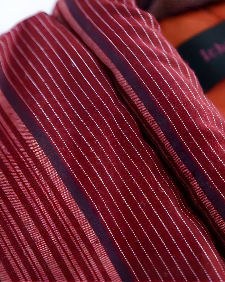 Détail du tissu rayé bordeaux d'un kimono. Texture raffinée et motifs élégants. Collection de kimonos de haute qualité.