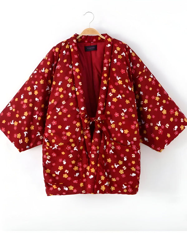 Kimono bordeaux à motifs floraux, suspendu sur un cintre. Vêtement traditionnel japonais, idéal pour un style unique et confortable. Découvrez notre collection de kimonos originaux.
