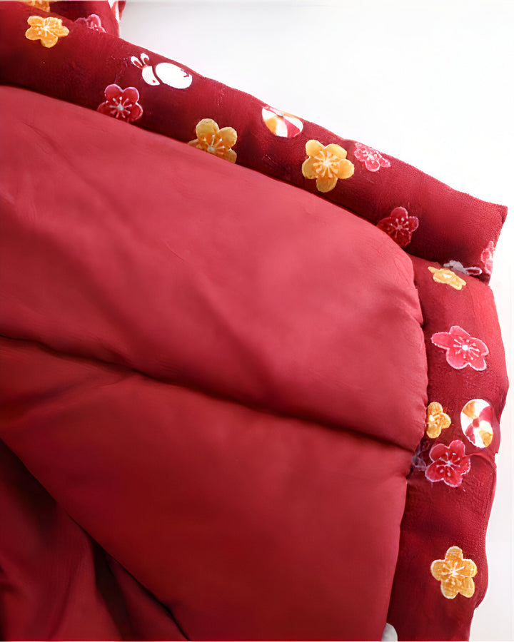 Détail d'un kimono rouge avec motifs floraux et lapins. Vêtements traditionnels japonais, parfaits pour une touche d'élégance. Découvrez notre collection de kimonos uniques !
