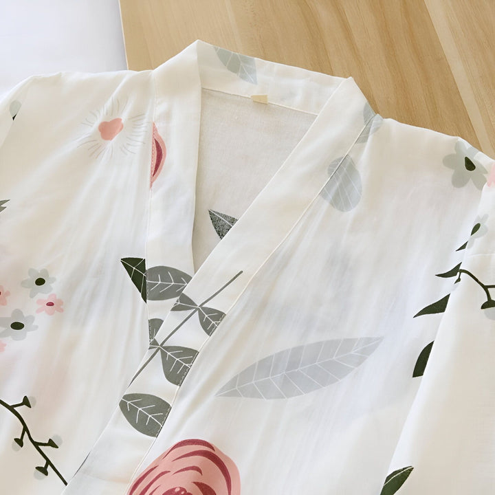 Détail d'un kimono blanc à motifs floraux roses et verts. Idéal comme vêtement d'intérieur confortable et élégant. Découvrez notre collection de kimonos uniques.