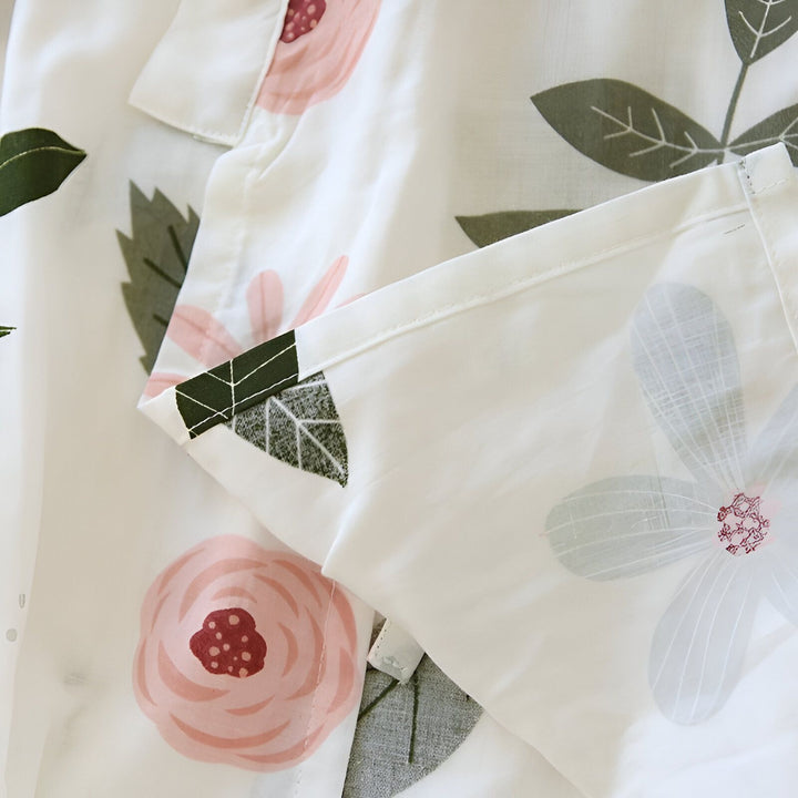 Détail d'un kimono blanc à motifs floraux roses et verts. Tissu léger, idéal pour l'été. Collection de kimonos fleuris.