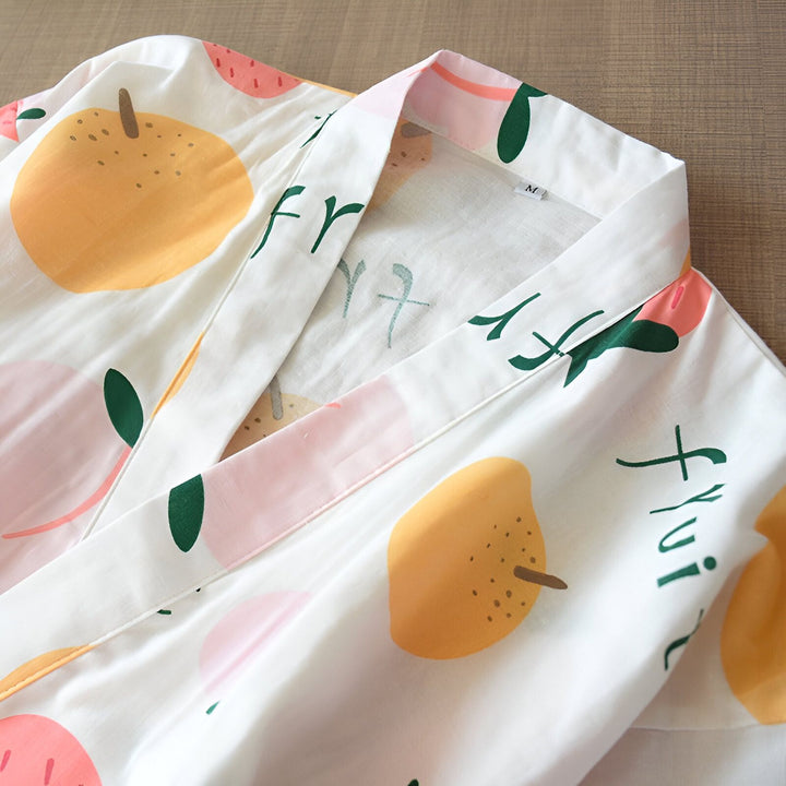 Kimono blanc à motifs de fruits colorés (pommes, pêches). Vêtement de détente confortable et élégant. Idéal pour se relaxer à la maison. Vente de kimonos en ligne.