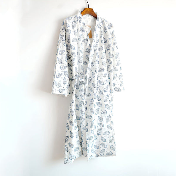 Kimono blanc à motifs de plumes bleues suspendu à un cintre. Vêtement confortable et élégant, idéal pour se détendre à la maison. Découvrez notre collection de kimonos uniques.