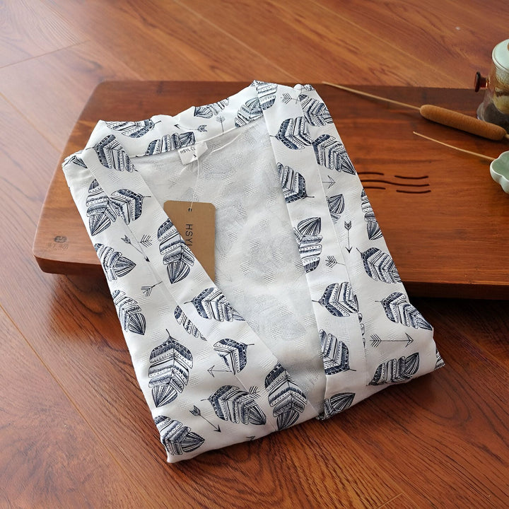 Kimono blanc plié avec motif de feuilles bleues. Vêtements japonais traditionnels en vente. Élégance et confort dans ce kimono unique.