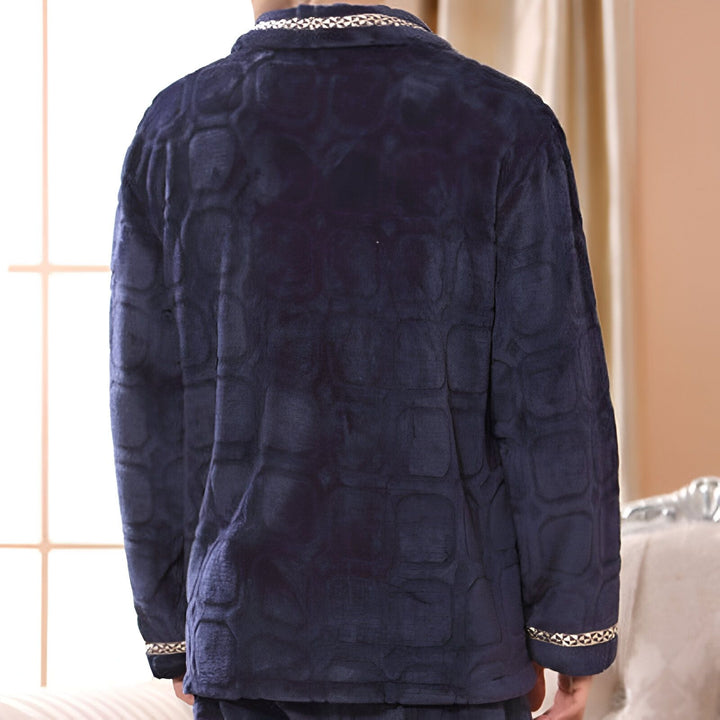 Dos d'une personne portant un kimono bleu marine texturé. Détails décoratifs dorés sur le col et les manches. Kimono de notre collection.