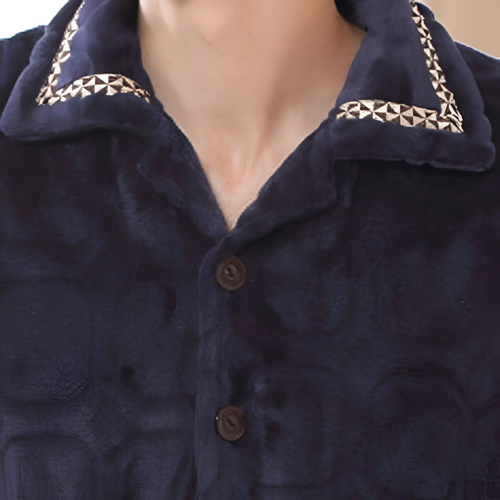 Détail d'un kimono en velours bleu marine avec col orné de motifs géométriques. Vêtement confortable et élégant, idéal comme peignoir ou tenue d'intérieur. Découvrez notre collection de kimonos!