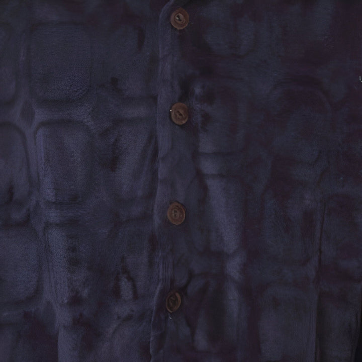 Détail d'un kimono bleu foncé avec des motifs texturés et des boutons marron. Parfait pour un look japonais authentique et élégant. Découvrez notre collection de kimonos.