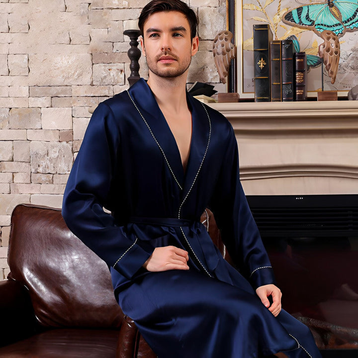 Homme portant un kimono bleu marine avec bordure blanche. Idéal pour se détendre à la maison avec style. Découvrez notre collection de kimonos luxueux.