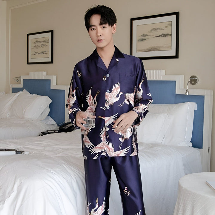 Homme portant un pyjama kimono bleu marine avec des motifs de grues blanches. Pyjama kimono élégant et confortable. Boutique de kimonos en ligne.