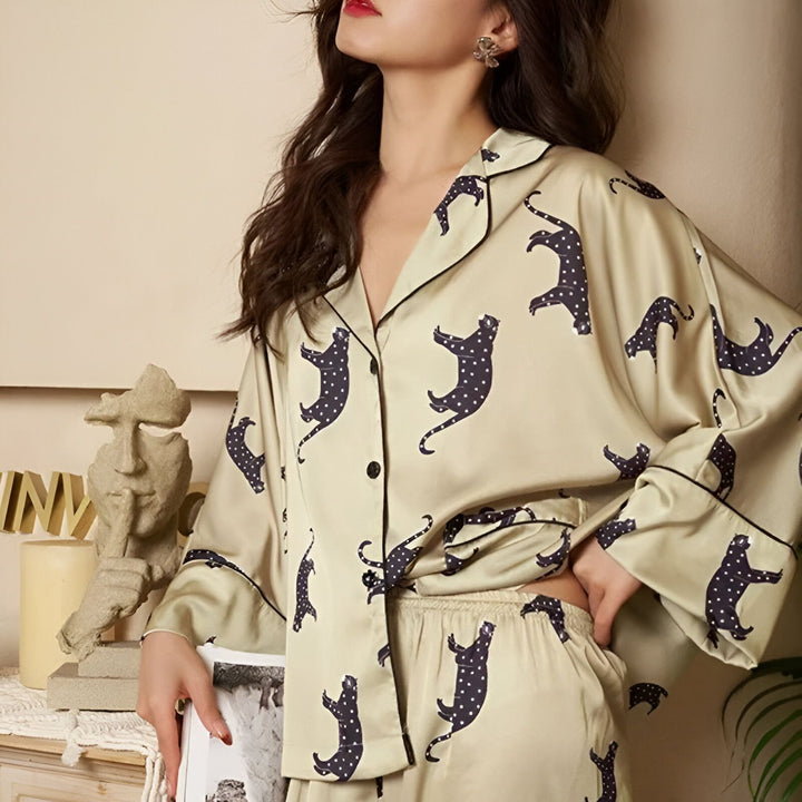 Femme portant un pyjama kimono beige avec des motifs de panthères noires. Vêtements de nuit confortables et élégants disponibles dans notre collection.