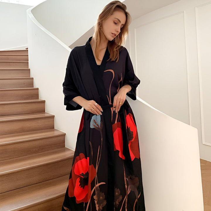 Femme portant un kimono noir à motifs de coquelicots rouges. Vêtements de style japonais, peignoir élégant. Kimono de notre collection.