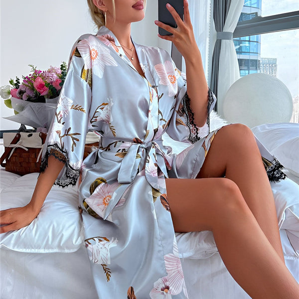 Femme en kimono fleuri prenant un selfie. Kimono en satin avec motifs floraux, parfait pour se détendre avec style. Découvrez notre collection de kimonos élégants.