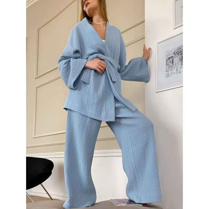 Femme portant un kimono bleu clair avec une ceinture assortie et un pantalon ample. Vente de kimonos en ligne.