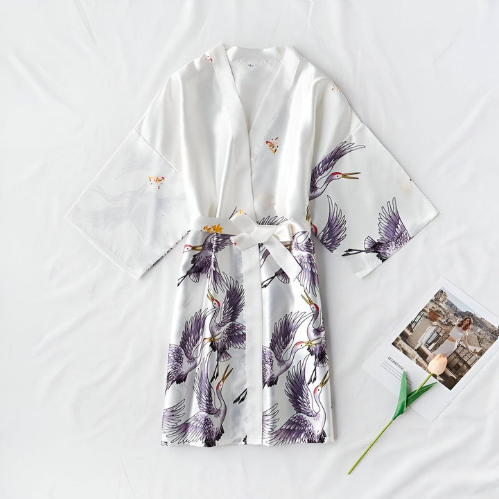 Kimono blanc à motifs de grues violettes. Vêtement traditionnel japonais, idéal pour la détente à la maison ou comme peignoir élégant. Découvrez notre collection de kimonos uniques.