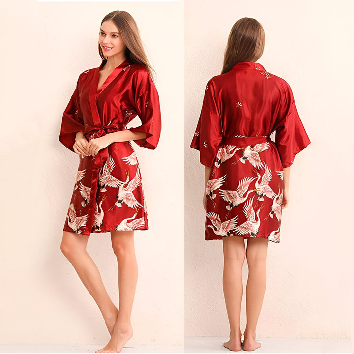 Kimono rouge en satin avec motifs de grues blanches. Vue avant et arrière d'un peignoir de style japonais, parfait pour la détente ou comme vêtement d'intérieur élégant. Découvrez notre collection de kimonos uniques et confortables.