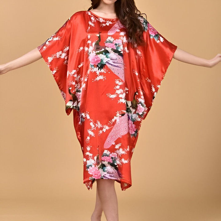 Femme portant un kimono rouge avec des motifs de paon et de fleurs. Vêtements de style japonais.
