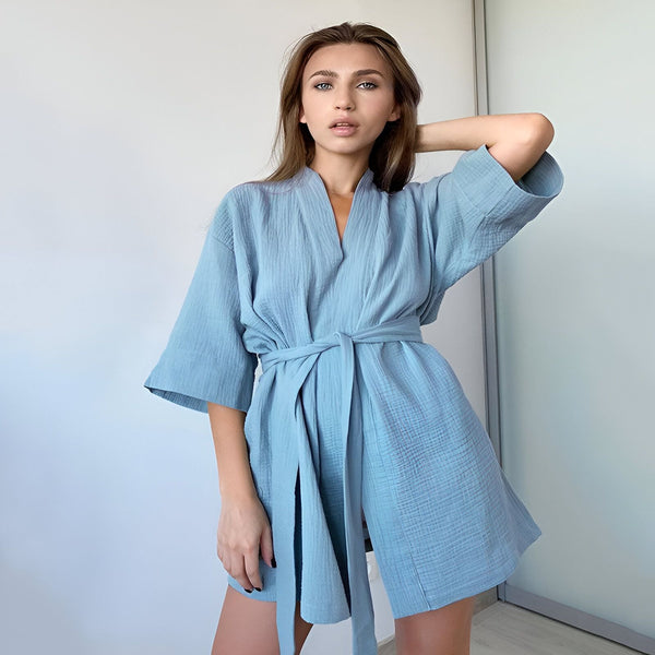 Femme portant un kimono bleu clair. Peignoir léger et élégant, idéal pour la détente. Découvrez notre collection de kimonos uniques.