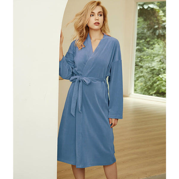 Femme portant un kimono bleu clair en velours. Peignoir kimono doux et confortable, idéal pour la détente à la maison. Découvrez notre collection de kimonos.
