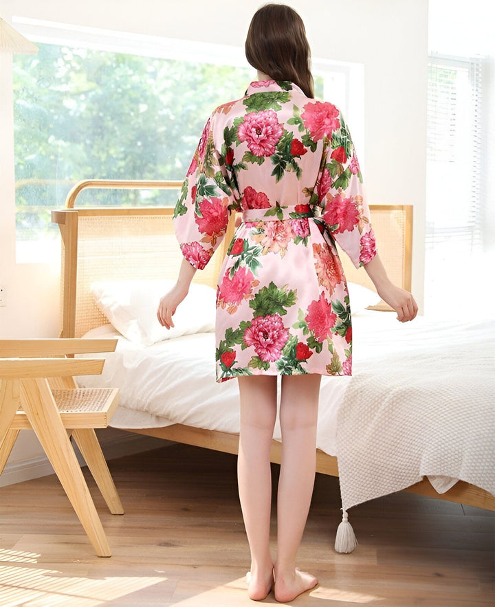 Femme portant un kimono court rose à motifs floraux. Vente de kimonos pour femmes, large choix de couleurs et motifs. Découvrez notre collection de kimonos en ligne.