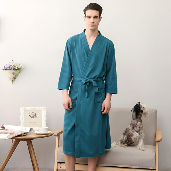 Homme portant un kimono bleu turquoise avec ceinture. Kimonos de haute qualité disponibles à l'achat. Chien à côté de l'homme.
