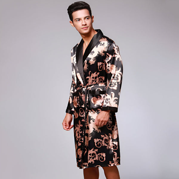 Homme portant un kimono noir et doré. Vente de kimonos pour hommes. Peignoir en soie avec motifs floraux et dragon, idéal pour la maison. Élégance et confort garantis.