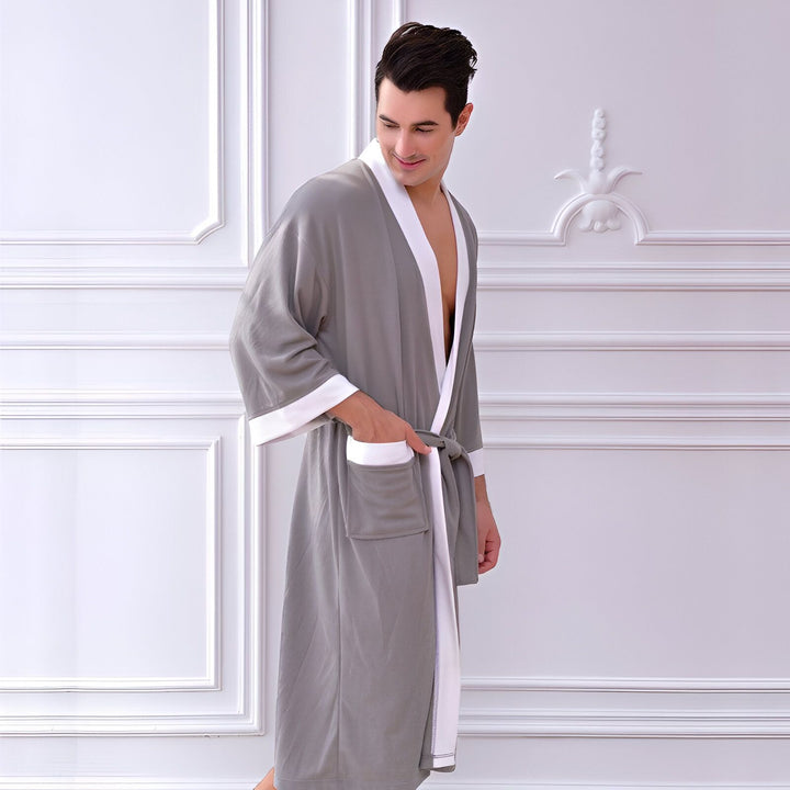 Homme portant un kimono gris avec bordure blanche. Peignoir confortable et élégant à vendre.