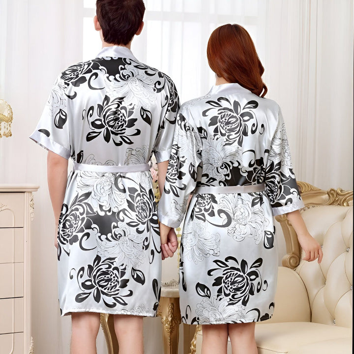 Couple portant des kimonos assortis à motifs floraux noirs et blancs. Vente de kimonos pour hommes et femmes. Mode japonaise traditionnelle. Kimonos élégants et confortables.